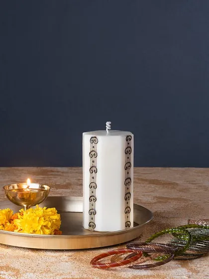 This hexagonal pillar candle features a geometric mehendi border, offering a more modern take on the traditional art form.