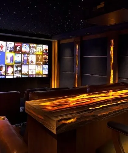 This entertainment space combines a high-performance home cinema with a custom-built, backlit onyx bar. It’s a perfect example of how we integrate leisure and luxury, creating a versatile room for both watching films and socializing.