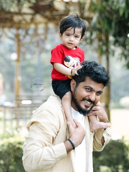 Another angle of a father giving his son a shoulder ride. The focus is on the child's happy expression and the strong bond between them.