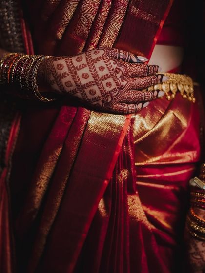 The rich maroon stain of the henna complements the bride's traditional red silk saree perfectly. This is the beautiful result of my all-natural henna paste.