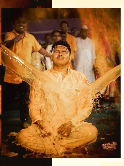 An action shot capturing the moment the groom is doused with turmeric water. It's a fun, unscripted part of the celebration that makes for a great memory.