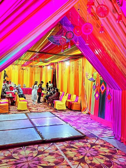 Another view of the lively Mehendi tent, showcasing the colourful ceiling drapes and spacious layout for dancing and celebration.