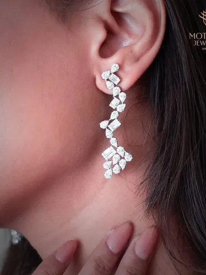 A cascade of brilliance. These long, dangling chandelier earrings are composed of various diamond cuts, designed to catch the light with every movement.