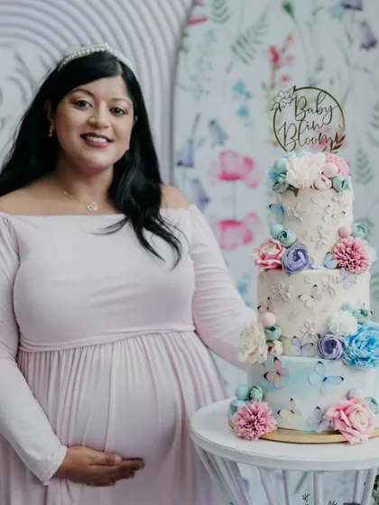 Here I am with the three-tier, all-buttercream cake for my own baby shower. This "Baby in Bloom" cake, with its hand-painted watercolor effect and sugar flowers, shows how I can create a stunning centerpiece for your most precious life moments.