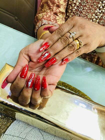 You can see how each stone is carefully placed to create a beautiful pattern on these festive red nails.