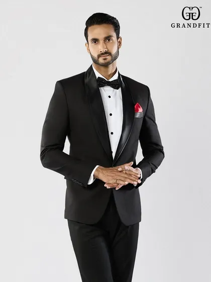 A closer look at the impeccable fit and finish of our classic tuxedo. Note the smooth satin lapel and the perfect placement of the bow tie, details that define our craftsmanship.