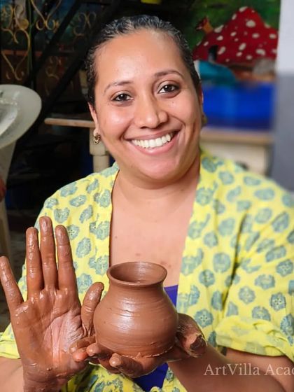 A happy student shows off her clay-covered hands and her first creation. Our workshops are designed to be fun, accessible, and rewarding for everyone.