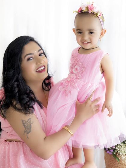 A happy and bright portrait of a mother holding her daughter. Their smiles are infectious!