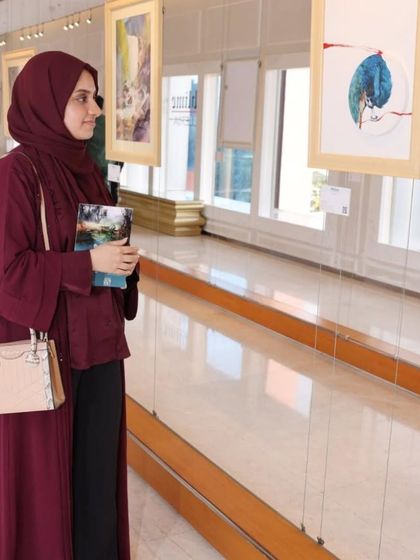 A visitor thoughtfully observing an artwork at the 'Ethereal Charm' show.