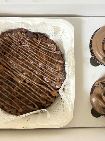 A top-down view of our brownie and cupcake combo box. You get a delicious, shareable brownie alongside two perfectly frosted cupcakes.