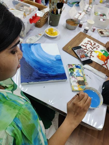 A collection of happy students from our adult canvas painting workshop, each holding their unique and beautiful landscape and abstract creations.