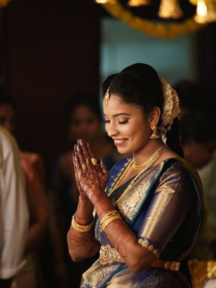 A moment of prayer for the bride. Her makeup is elegant and understated, suitable for the solemnity of the wedding rituals.