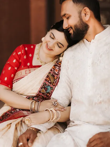 A quiet moment of comfort and affection. This close-up from a heritage location shoot focuses on the gentle emotions shared between the couple, highlighting their traditional attire and serene bond.