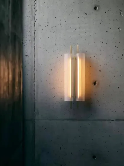 The Volant system also includes this elegant wall sconce, which features the same textured, tubular glass and brass detailing, allowing for a cohesive lighting scheme throughout a project.