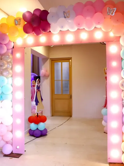 A light-up balloon archway welcoming guests to a princess-themed 4th birthday party at a villa in Madh Malad West.