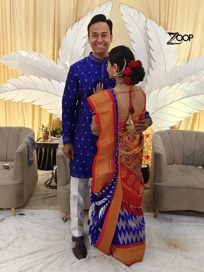 A beautiful moment between a couple on their special day. The groom looks sharp and elegant in a classic blue kurta, perfectly complementing his bride's traditional saree.