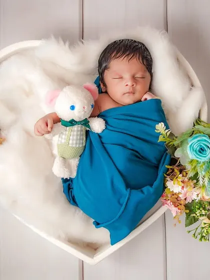 There is nothing more pure than a sleeping newborn. For this portrait, I used a heart-shaped basket and soft white fur to gently cradle the baby, creating a timeless image of peace and new love.