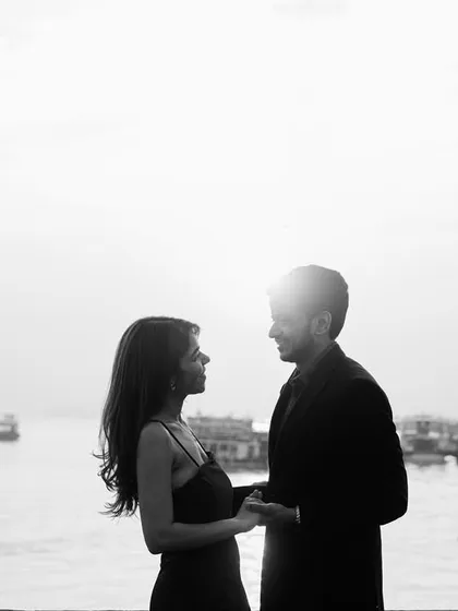 A romantic silhouette against the bright sky and water, this black and white photo focuses on the couple's connection and the iconic location.