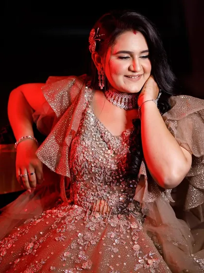 A dramatic shot with red lighting, highlighting the sparkle and dimension of her reception makeup. This look is designed to be versatile and look great in any lighting.
