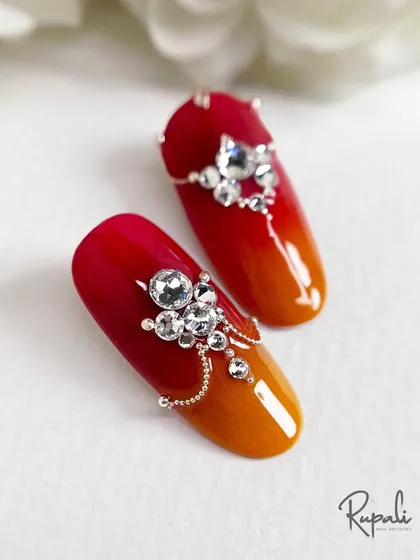 A beautifully composed shot of the fire-dipped nails, showcasing the intricate jewellery work.