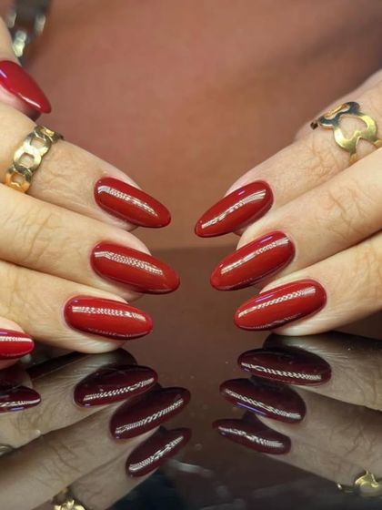 A classic and powerful statement with a glossy, rich red polish on perfectly shaped oval nails.