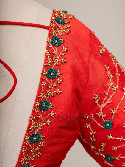 A simple yet striking design. This bright red raw silk blouse features a delicate creeper embroidery pattern in gold and teal thread, with a classic square back and matching handmade tassels.