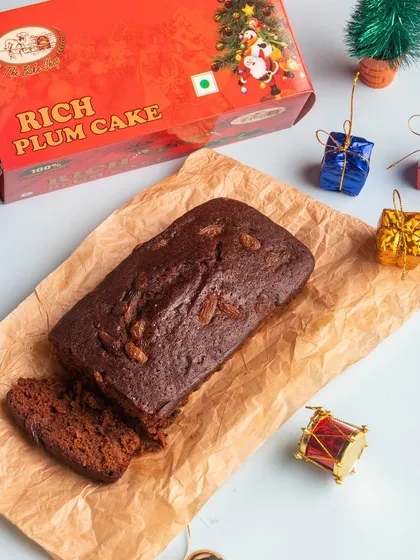 Our signature rich plum cake, sliced and ready to serve. It's loaded with dry fruits and nuts, offering warmth and spice in every bite.