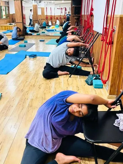 A wider view of our class practicing chair-assisted side bends. Notice how everyone can work at their own level, finding the stretch that is right for their body.