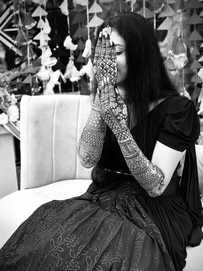 A beautiful black and white photo of a bride, highlighting the texture and density of her full-arm bridal mehandi.