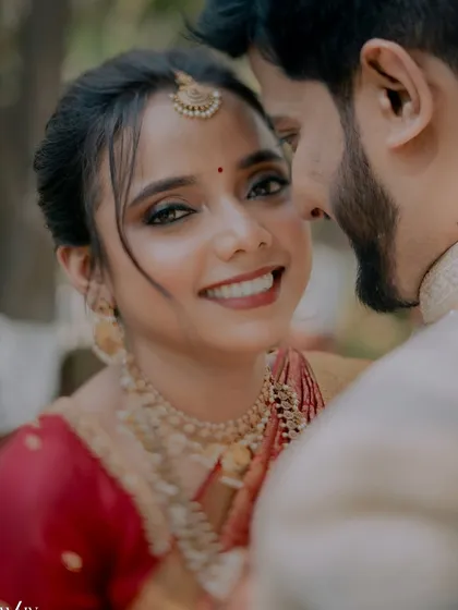 A close-up that captures the bride's beautiful smile and the intricate details of her smokey eye makeup.