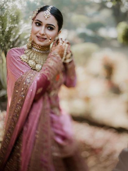 A soft-focus, artistic shot of the bride in a garden setting. This image captures the dreamy, romantic feel of her wedding day look.