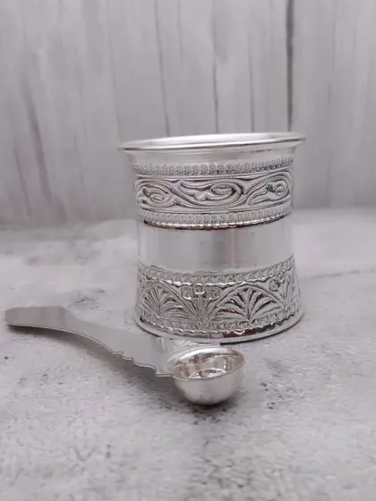 A German silver panchapatra set, including the glass and a matching spoon (uddharani), essential for performing rituals.