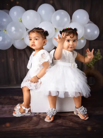 Capturing the adorable energy of twins is always a joy. This studio portrait of two sisters dressed in white shows how I create simple yet beautiful setups that keep the focus on the children's interaction.