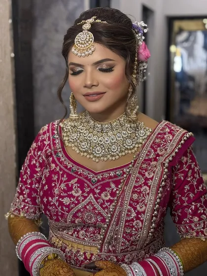 This bride's makeup is all about soft glamour. The skin is luminous, and the eyes are subtly defined, allowing her natural beauty and stunning jewellery to take center stage.