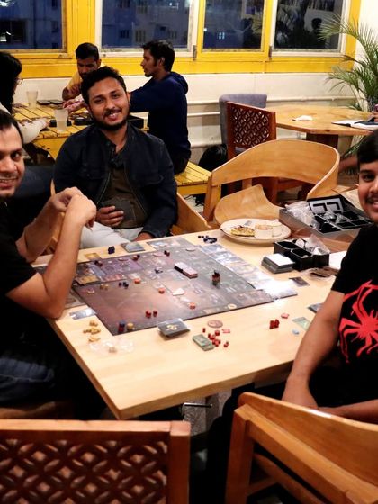 Even with a complex board game set up, there's still room for smiles and good company. This is what our board game meetups are all about.