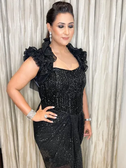 All about the drama. Her intense, glittery black smokey eyes are the star of the show, paired with a braided ponytail for a fierce and fashionable cocktail look.