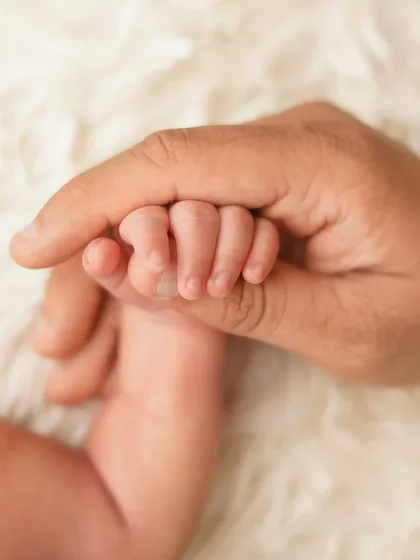 A newborn's hand wrapped around their parent's finger. It's a simple, beautiful illustration of trust and the instant bond they share.