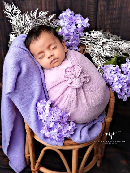 A wider view of the purple rattan chair setup, showing the arrangement of flowers.