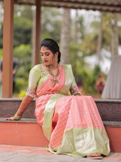 A full-length view of the engagement saree look. The soft makeup complements the delicate colors of the saree and the traditional gold jewellery.