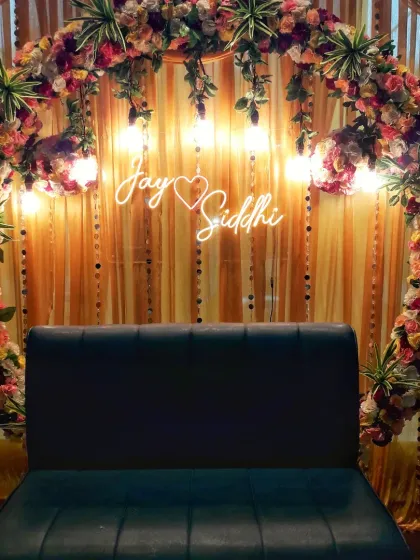 I offer personalized backdrops for events like engagements and roka ceremonies. This circular floral arch includes a custom neon sign with the couple's names, making it a unique and memorable photo spot.