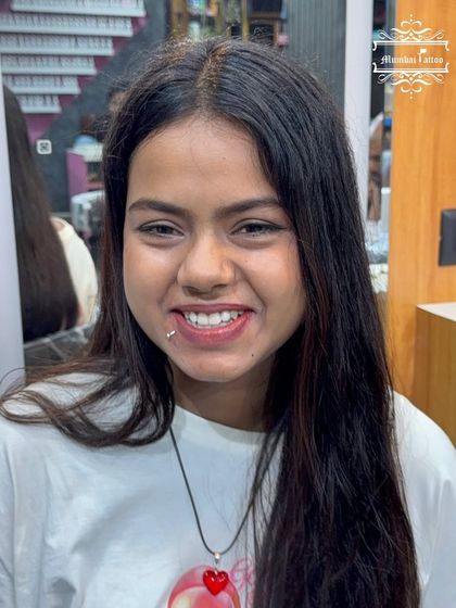 A happy client showing off her new labret (lip) piercing. We ensure symmetrical placement for a look that enhances your smile.