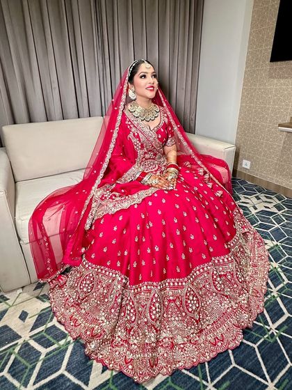 A full-length shot of this traditional bride in red. The makeup is designed to be photogenic and long-lasting, ensuring she looks perfect throughout the ceremony.