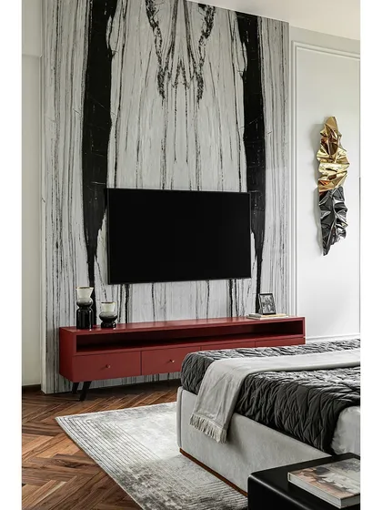 This shot highlights the dramatic book-matched marble panel behind the TV in the master bedroom. It serves as a stunning piece of natural art, creating a powerful focal point in the room.