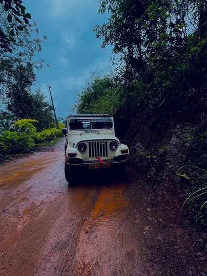 An off-road jeep on a muddy track in Chikmagalur. The journey to the peaks is an adventure in itself.