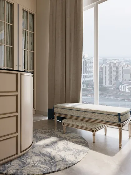 A custom upholstered bench provides a comfortable spot for getting ready, positioned to take advantage of the natural light from the large window.
