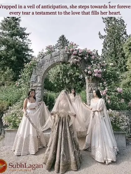 Surrounded by her bridesmaids under a beautiful stone arch, a bride is wrapped in her veil. We foster matches where the union is celebrated by the entire community.