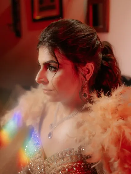 An artistic and glamorous portrait of the bride, Rozy, at her sangeet. The use of a prism creates a beautiful rainbow flare, adding a touch of magic to the shot.