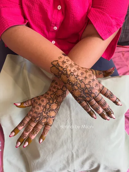 A delicate and intricate net or 'jaali' pattern covering the entire hand. This style is timeless and offers a look of detailed lacework on the skin.