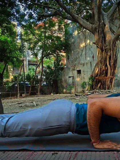 I am holding Chaturanga Dandasana, or Four-Limbed Staff Pose, a key part of Vinyasa flows. It is an arm balancing pose that builds immense strength in the arms, legs, and core muscles.