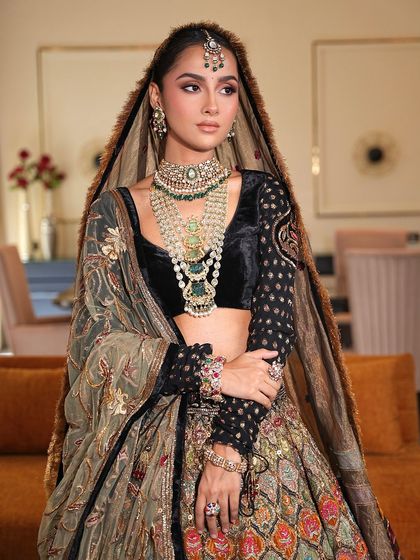 A closer view of the bride's soft glam makeup. The look features a neutral eye and a natural lip, allowing the intricate details of her jewelry and the rich velvet of her blouse to stand out.